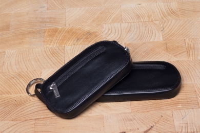 <h5>3965 45</h5><p>Key case with zip in black with 2 key chains and front zip compartment. Size: 12 x 6,5 cm																	</p>